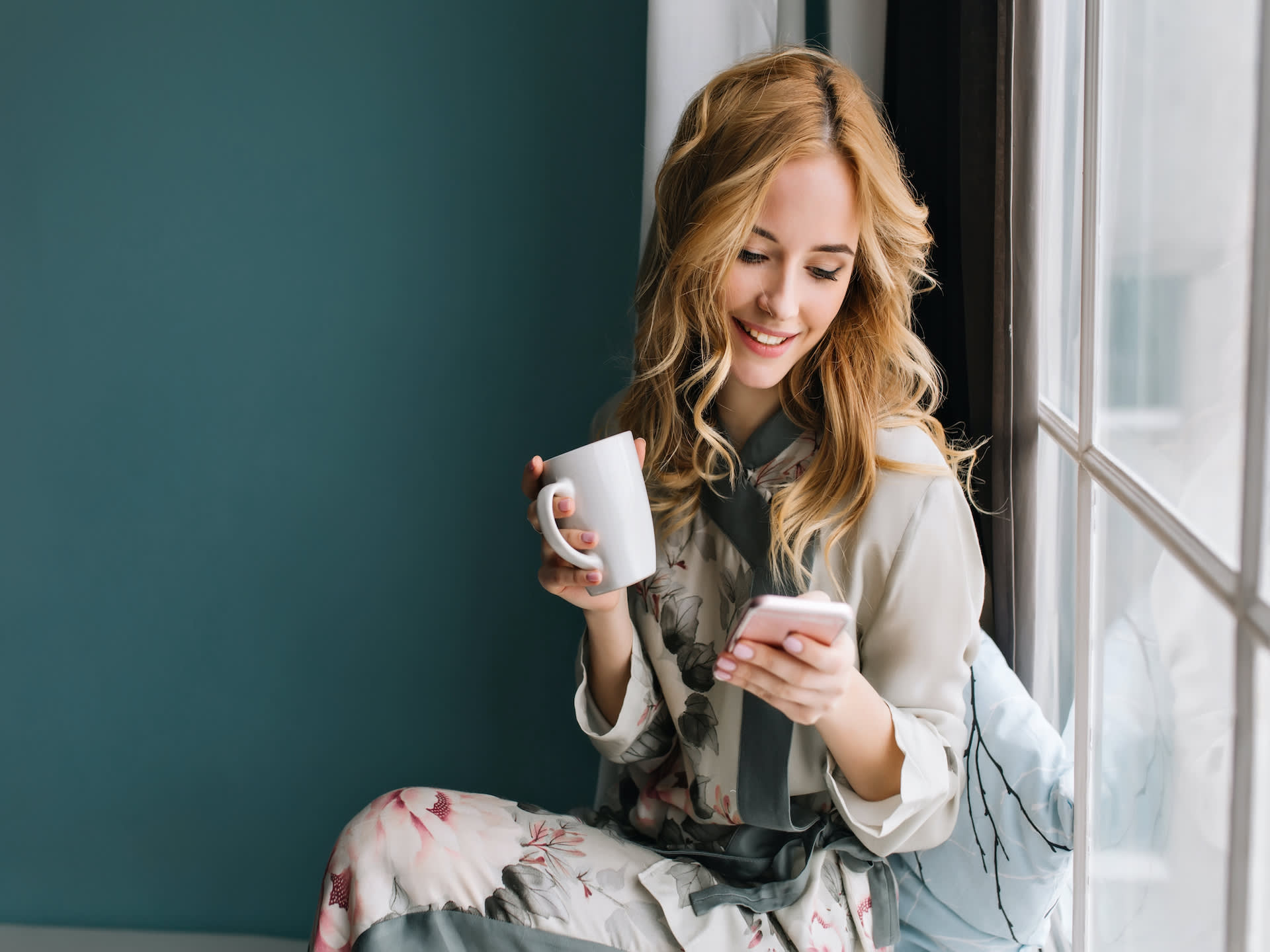 woman at window looking at phone app